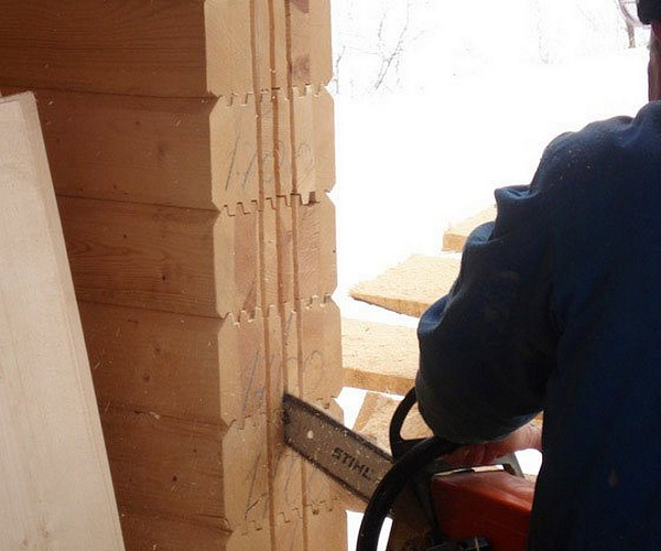 В оконных и дверных проемах вырезаются пазы под обсадные бруски (ройки).